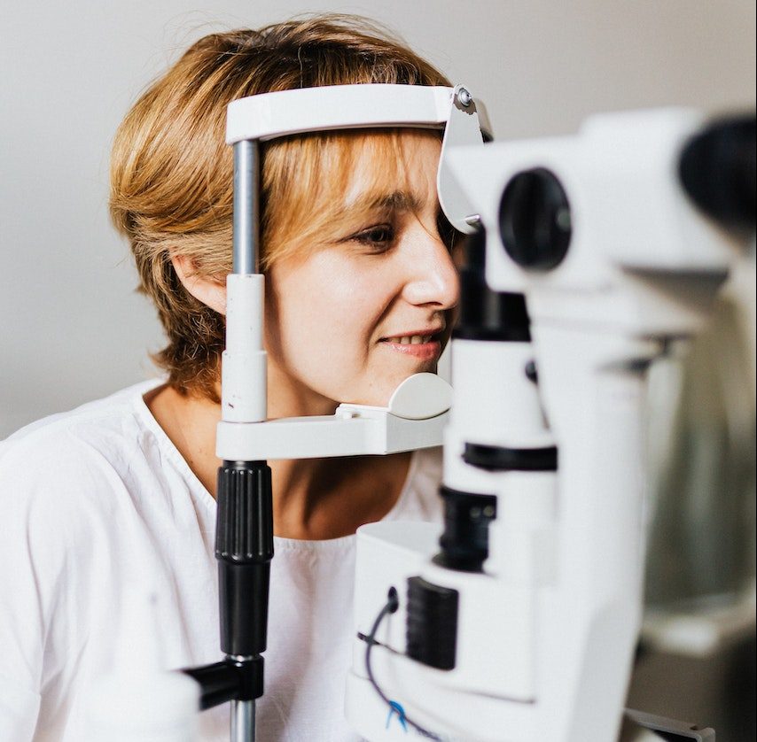 A Woman in White Shirt Having an Eye Test Using an Equipment